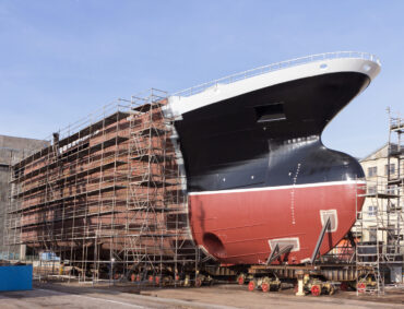 Hull of ship under construction at shipyard.